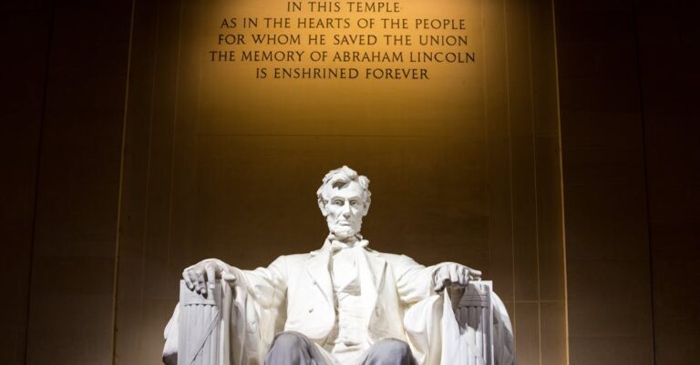 Illuminated Lincoln Memorial statue with engraved quote, Washington D.C.