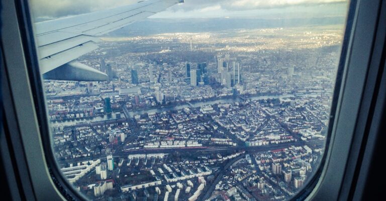 Stunning aerial view of Frankfurt am Main through an airplane window, showcasing the city's skyline and architecture.