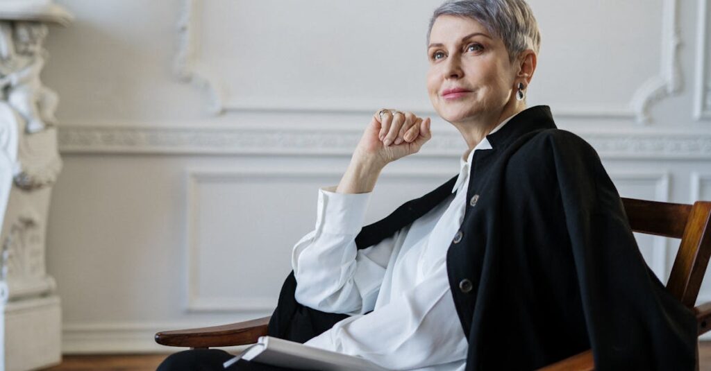 Senior woman with short hair seated indoors, exuding confidence and elegance in a classic setting.