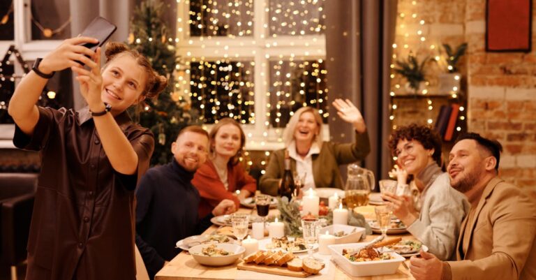 A joyful family capturing a selfie during a festive Christmas dinner indoors.