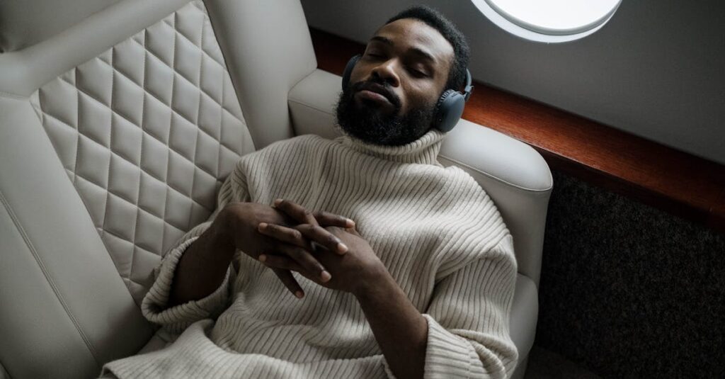 A businessman enjoys music on headphones while relaxing in a private jet. Luxurious travel concept.