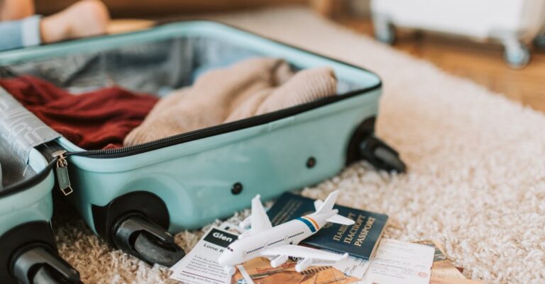 Close-up of an open suitcase with travel essentials like passport and tickets, ready for a journey.