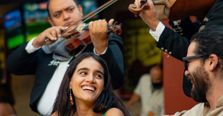 Friends enjoying music at a Mexican restaurant with mariachi band.