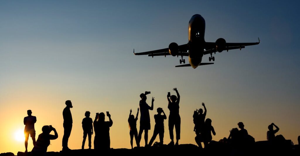 A dynamic silhouette of people photographing an airplane during a vibrant sunset.