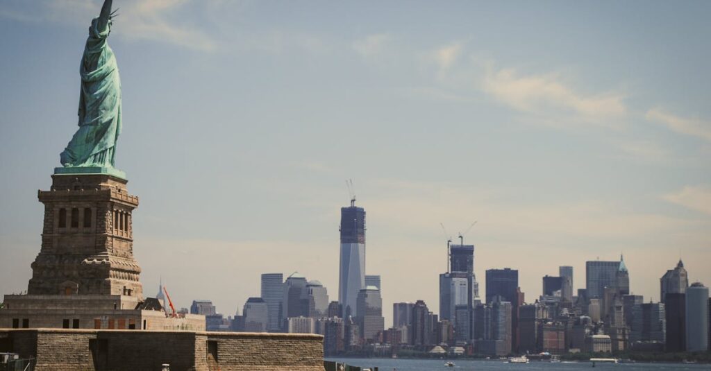 The Statue of Liberty stands majestically with New York City's skyline in the background, seen from the waterfront.