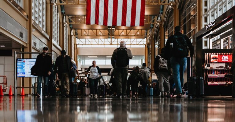 Travelers walk under an American flag in the atrium of Reagan Airport, Washington D.C.