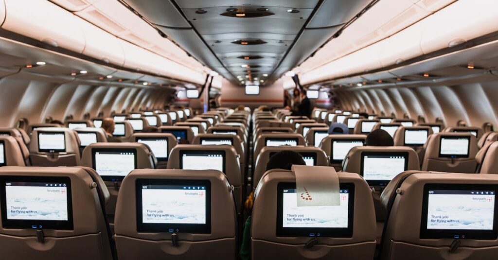 Comfortable airplane cabin interior featuring in-flight entertainment screens on all seats.