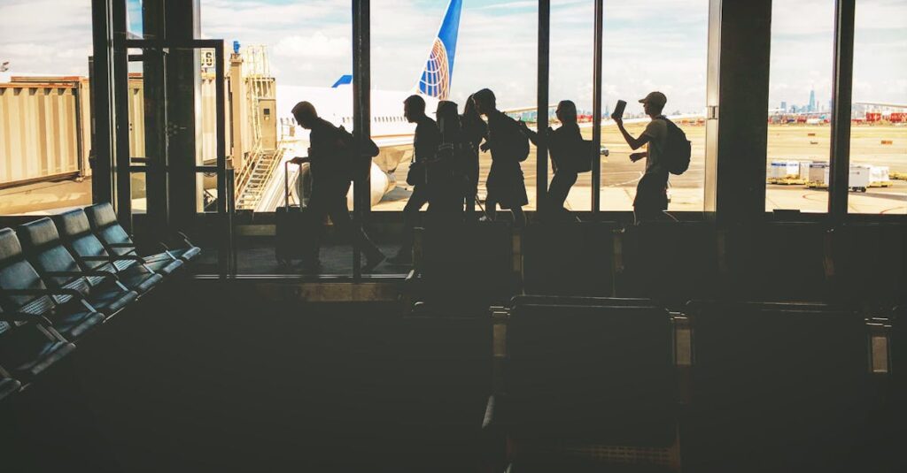 Silhouettes of travelers at an airport gate, airplane and city skyline visible through windows.