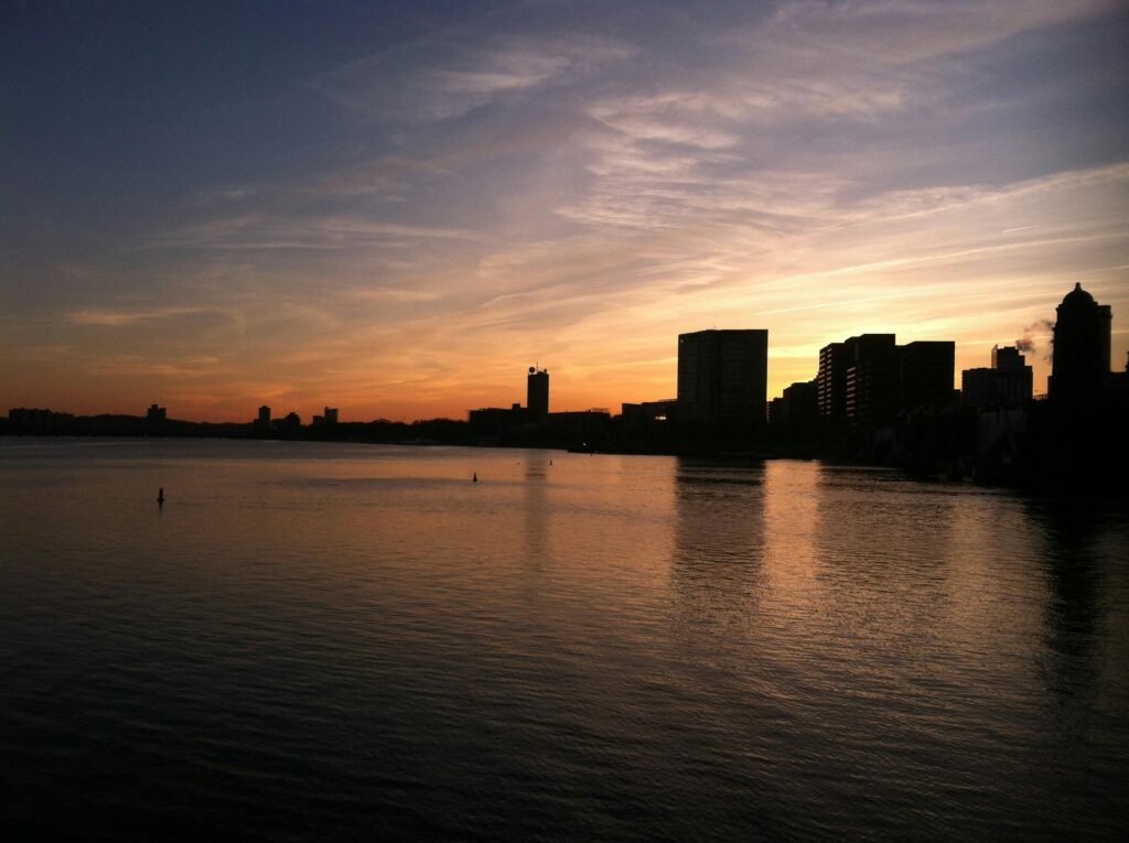 Captivating view of Boston's skyline in silhouette against a colorful twilight sky.