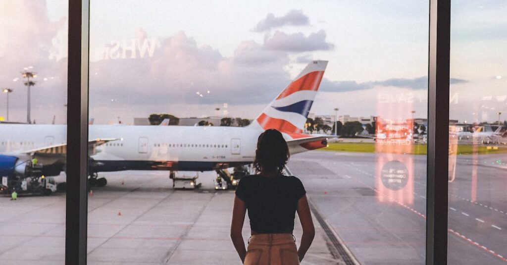 A woman stands at a glass window viewing airplanes at Singapore Airport, capturing the essence of travel and anticipation.