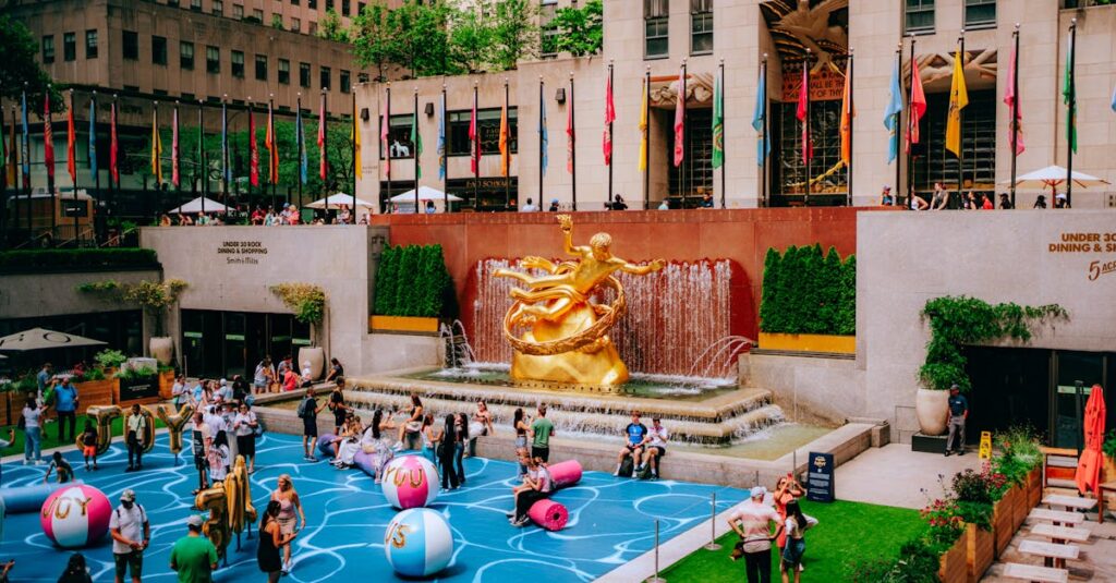 Vibrant scene at Rockefeller Center with the iconic Prometheus statue, flags, and playful activities.