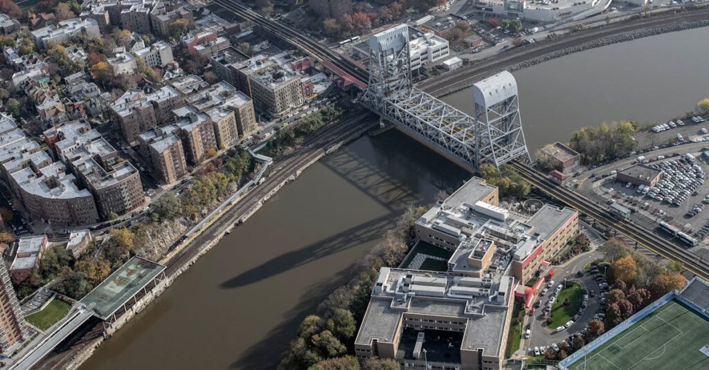 Aerial shot of New York City's urban landscape featuring a bridge over a river and residential buildings.