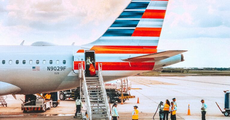 A colorful airliner being prepared for boarding on a sunny day at an airport.