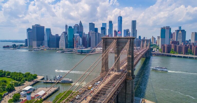 Breathtaking aerial view of the iconic Brooklyn Bridge and Manhattan skyline under a clear sky.