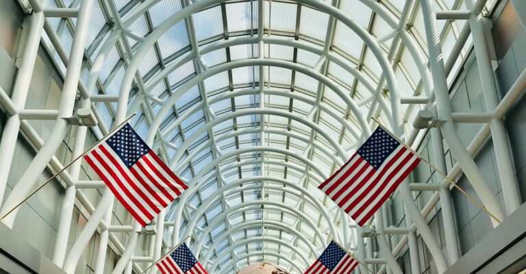 Interior of Chicago O'Hare Airport with American flags and globe sculpture.