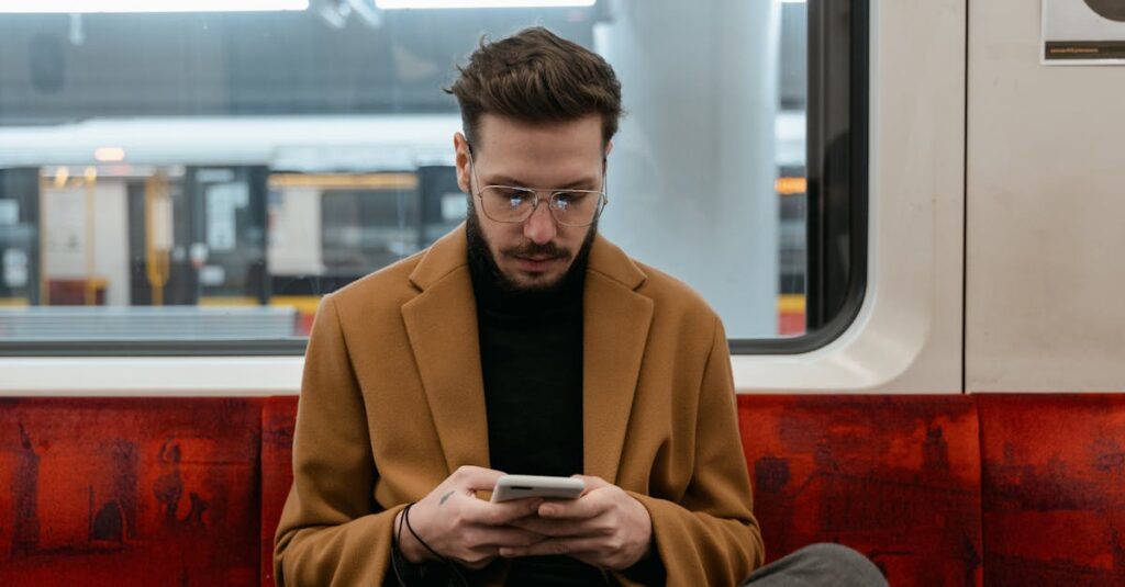 Young man using smartphone on a subway, focused and commuting.