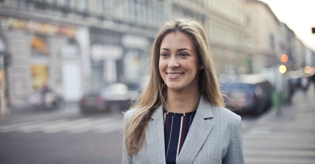 Confident businesswoman smiling outdoors in urban Budapest setting.