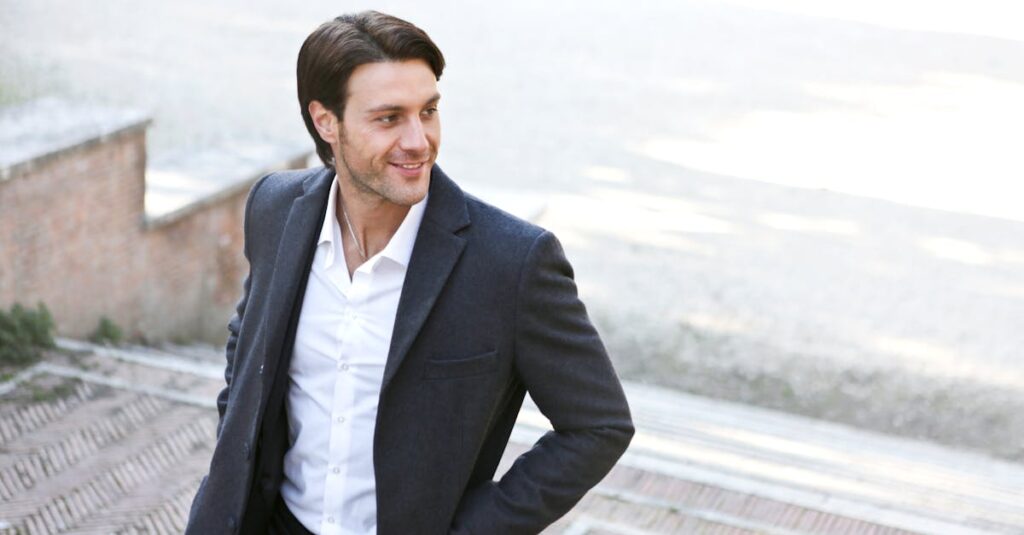 Confident man in a suit smiling while walking outdoors, showcasing fashion and style.