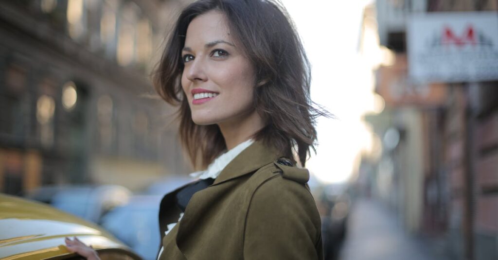 Portrait of a fashionable woman smiling beside a yellow taxi on a lively city street.