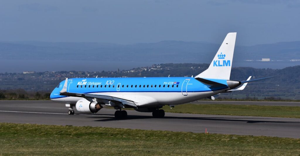 A KLM Cityhopper Embraer plane prepares for takeoff on a sunny day.