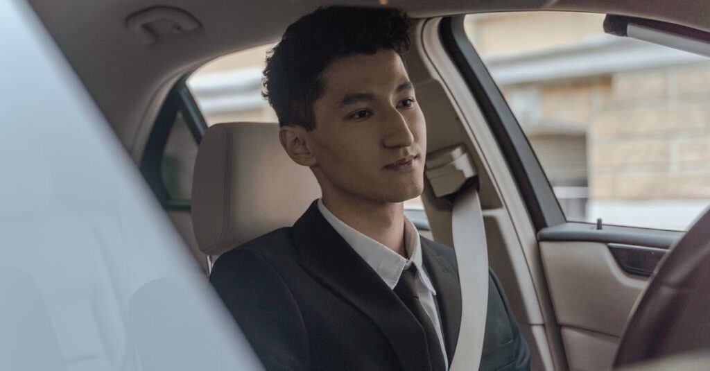 Young professional driver in formalwear inside a modern car, looking focused and attentive.