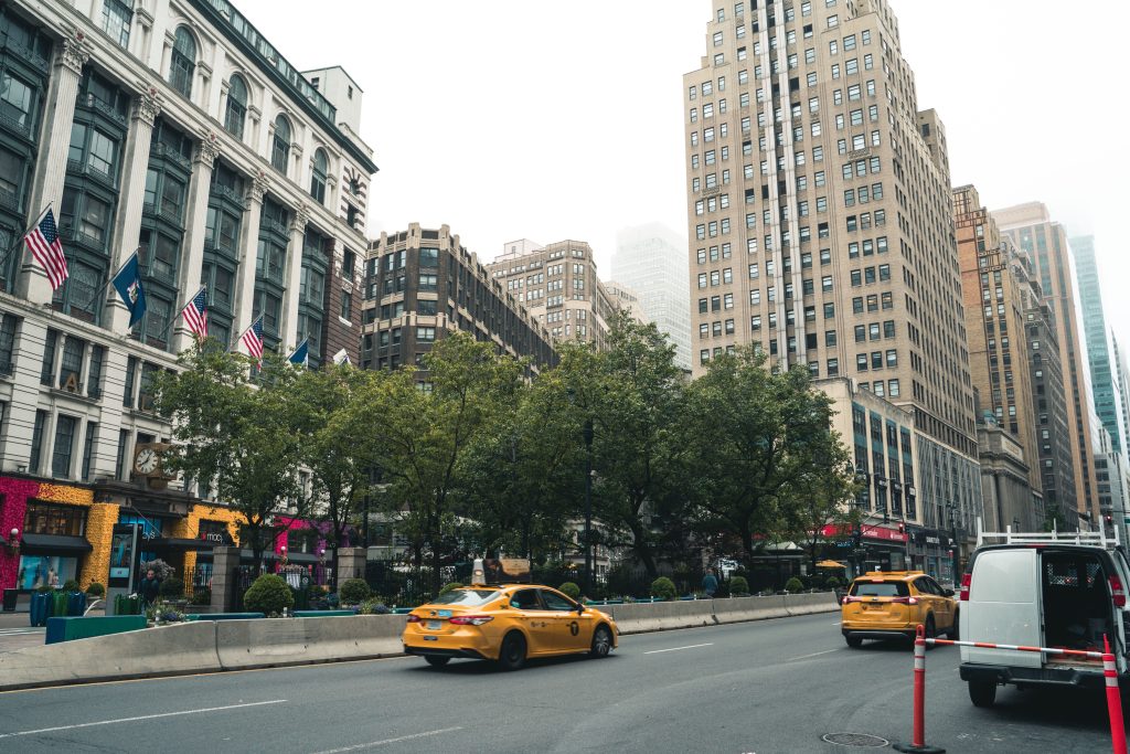 Reliable Manhattan Taxi: Honest 2026 Buyer’s Guide 3 Urban scene showcasing busy New York City street with yellow taxis, towering skyscrapers, and vibrant storefronts.