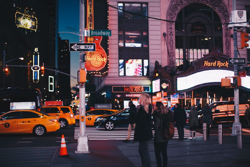 Manhattan Taxi Reviews 2026: The Honest Booker's Guide 7 A bustling street view of Broadway at night featuring Hard Rock Cafe, taxis, and pedestrians in New York City.