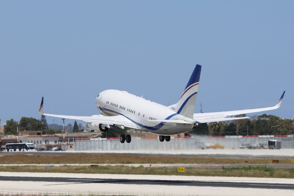 A commercial airplane takes off from a runway on a clear day, showcasing aviation and travel concepts.