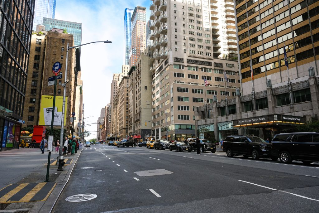 How Much Is a Manhattan Taxi? 7 Honest 2026 Costs 5 Urban cityscape of Midtown Manhattan with skyscrapers, vehicles, and pedestrians.