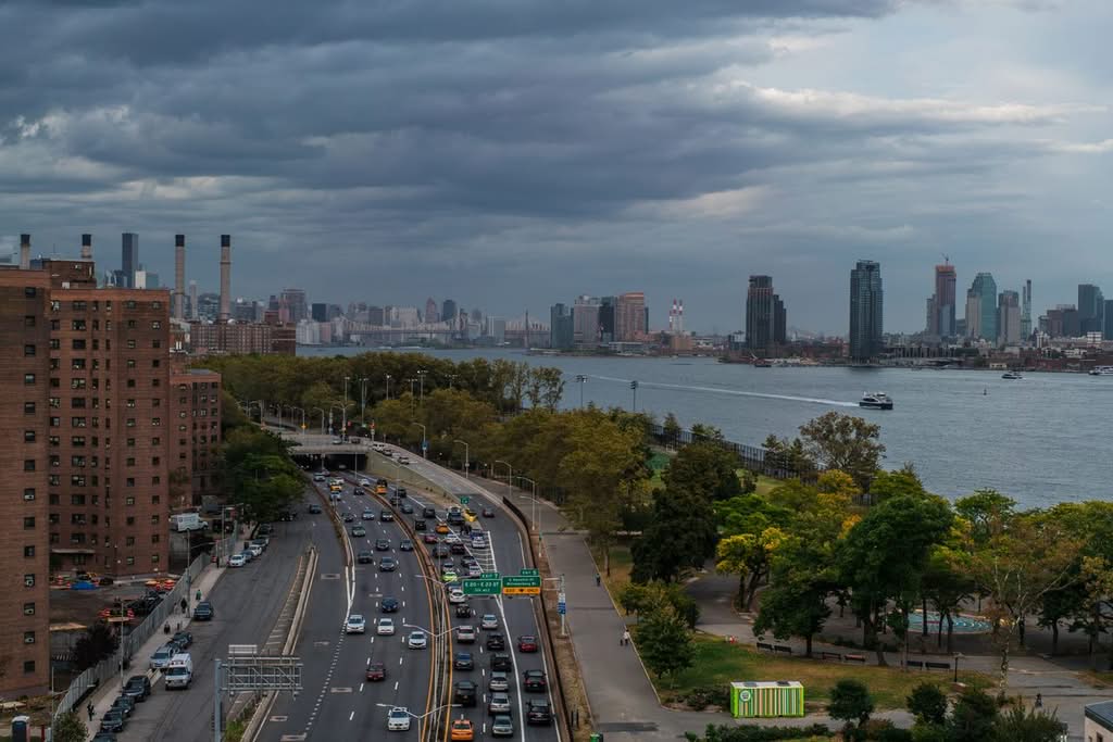 Aerial view of bustling New York City highways and skyline along the East River.