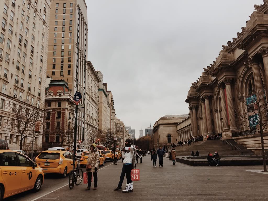 How Much Is Cab Fare From JFK to Manhattan? Honest 2026 Guide 13 Busy street view outside the Metropolitan Museum of Art with taxis and pedestrians in New York.