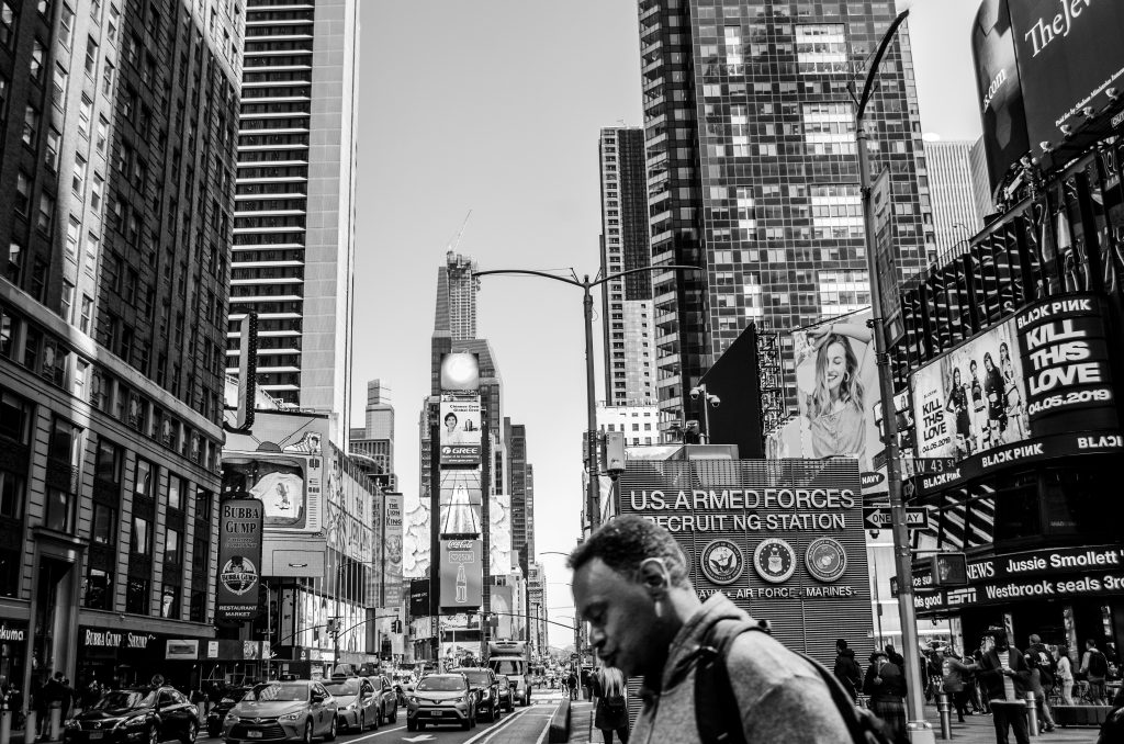 NY Car Service LGA Reviews 2026: 5 Honest Things Corporate Bookers Need to Know 7 Black and white photo capturing the lively atmosphere of Times Square, NYC.