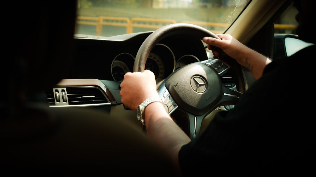 Luxury Taxi Ride from JFK to Manhattan: 7 Honest Facts (2026) 13 Close-up of a driver steering a Mercedes-Benz through Bengaluru, India.