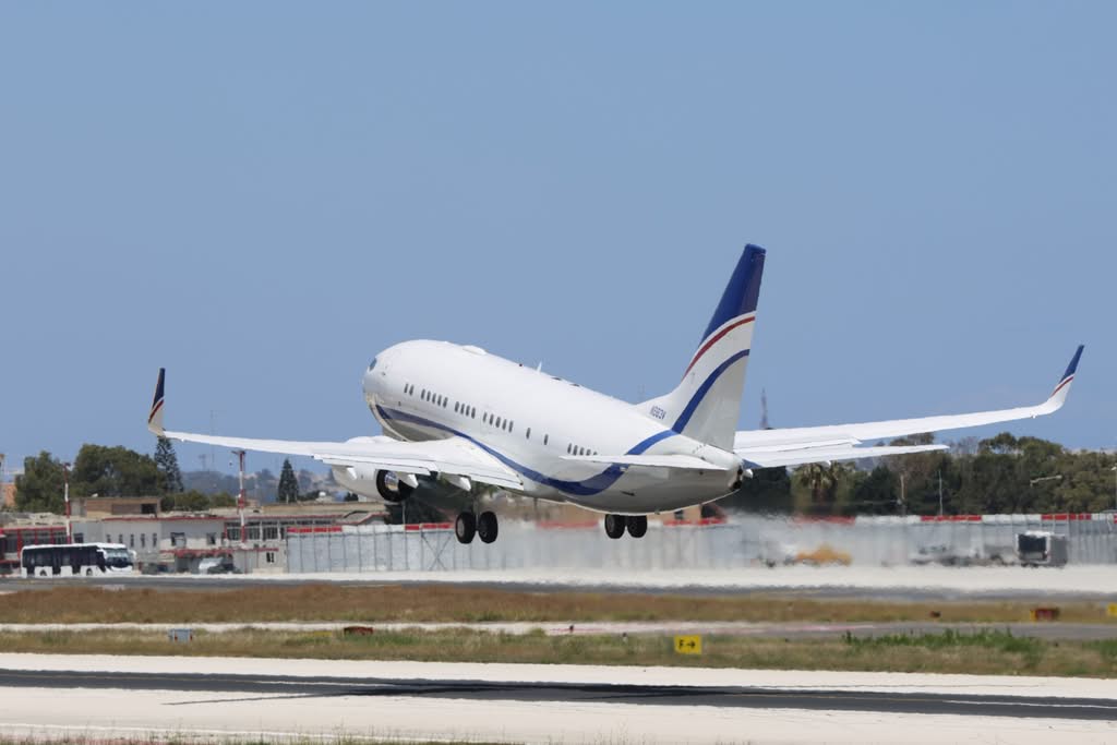 A commercial airplane takes off from a runway on a clear day, showcasing aviation and travel concepts.