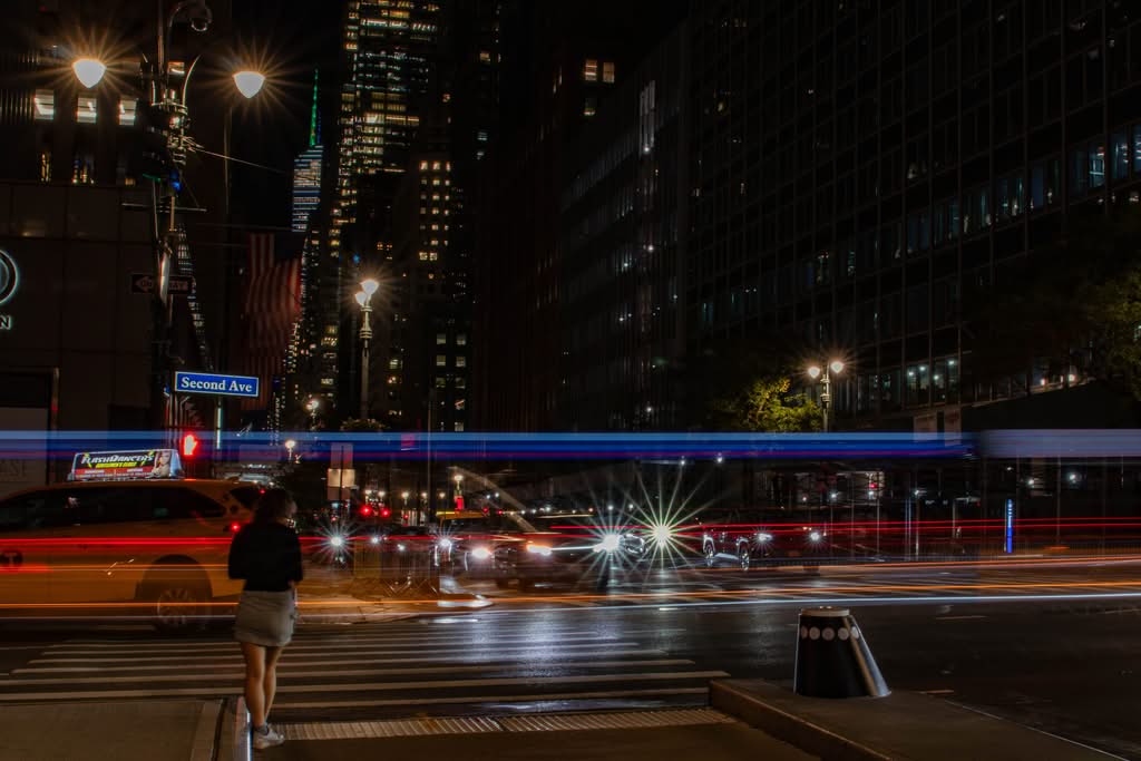 Affordable Manhattan to JFK Taxi: 6 Honest Family Costs (2026) 11 Vibrant city night scene with light trails on Second Ave, NYC showing dynamic urban life.