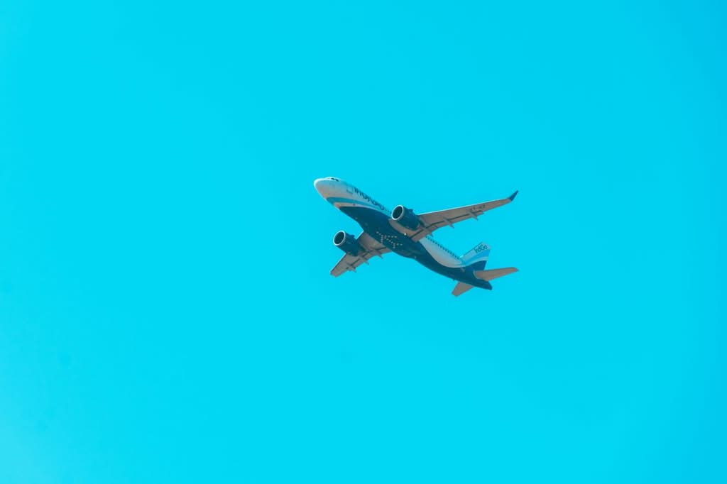Transportation from LaGuardia to JFK for Groups: The Honest 2026 Test of LGA to JFK Group Airport Transfer Costs 7 A commercial jet soars through a bright blue sky, showcasing aviation power.