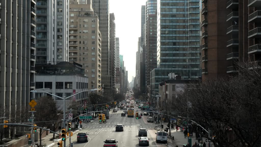 A bustling New York City street flanked by modern high-rise buildings, showcasing urban life.